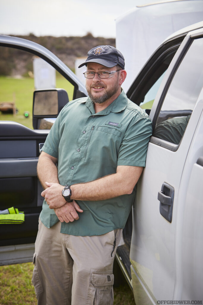 Photo of John Hearne posing next to a white pickup truck.