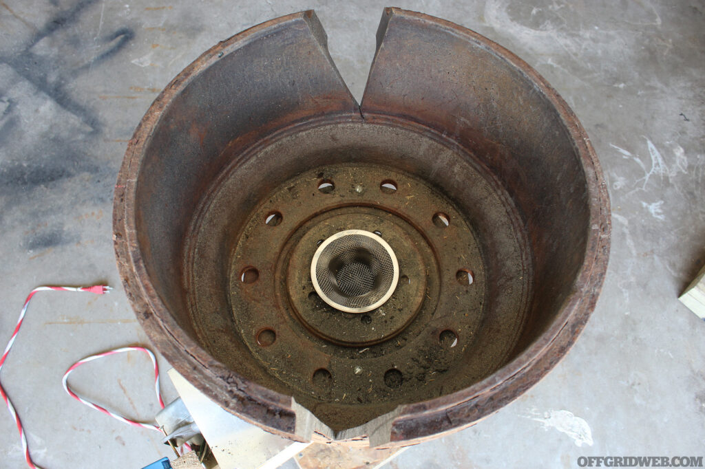 View of the inside of a large brake drum that has been modified to act as a makeshift forge.