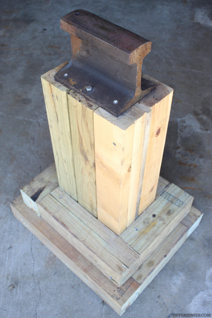 Photo of a small chunk of railroad track being used as a makeshift anvil.