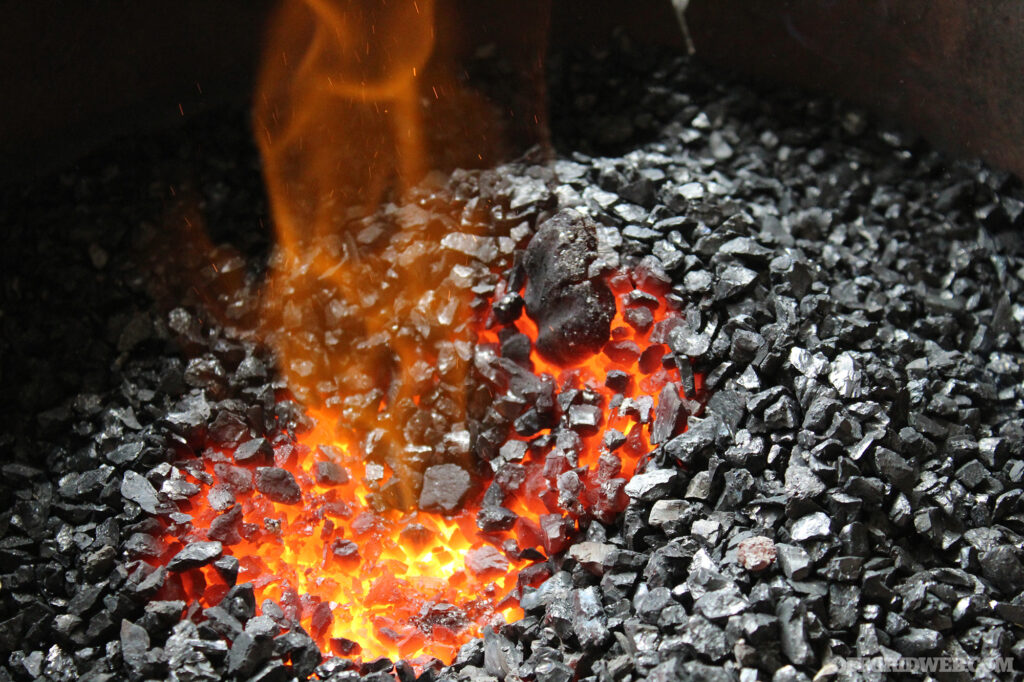 Photo of lit mineral coals, glowing with heat and flame.