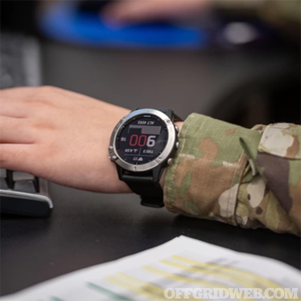Photo of a smartwatch being worn by someone in a camouflage military uniform.
