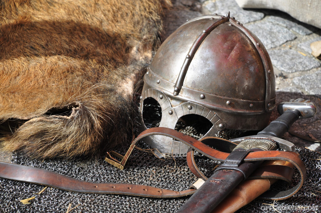 Photo of tanned hide next to an steel helmet and sword.