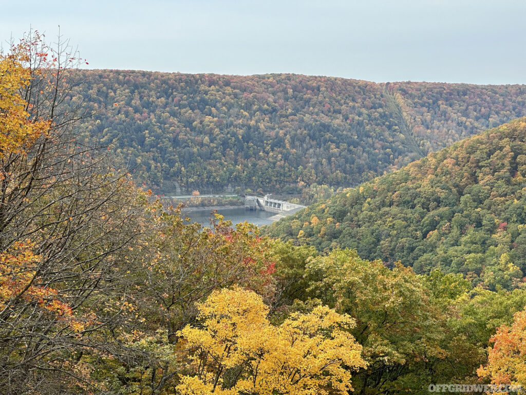 Photo of a dam located in the heavily forested valley of the Allegheny wilderness.