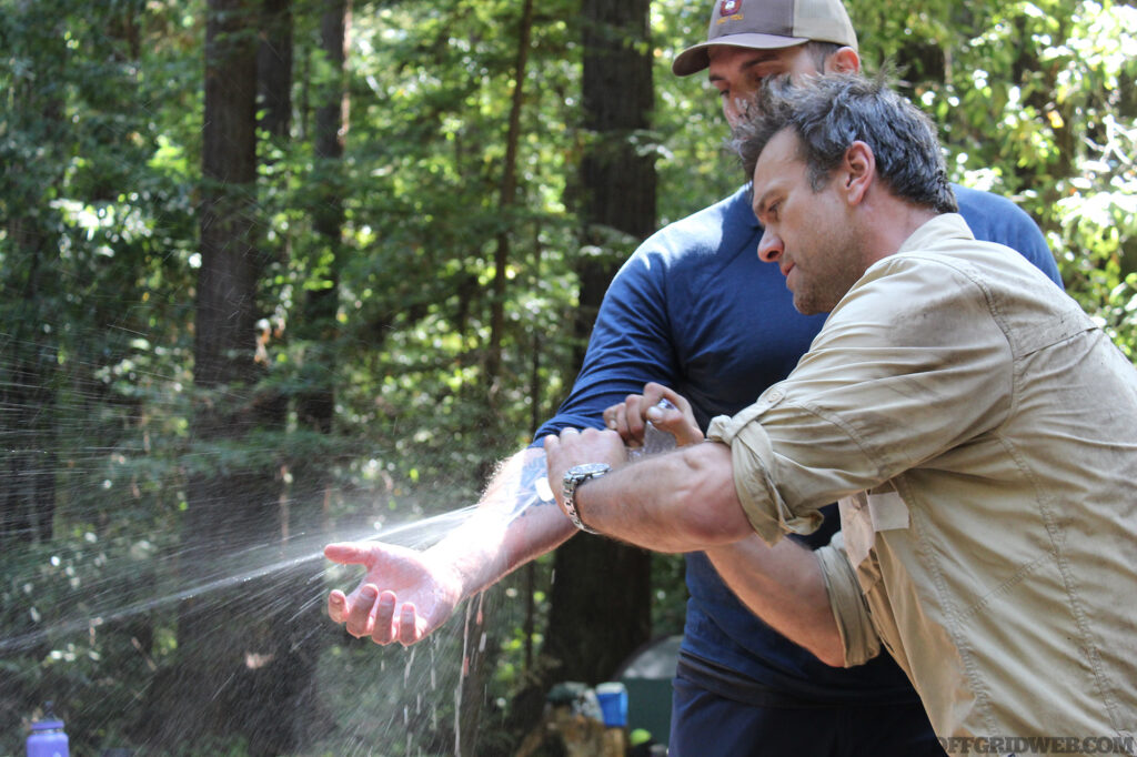 Adam Mayfield using a water bottle to to rinse a wound clean.