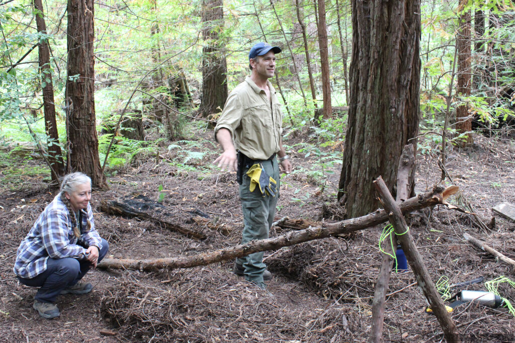 Adam and Amy constructing an A-frame debris shelter.