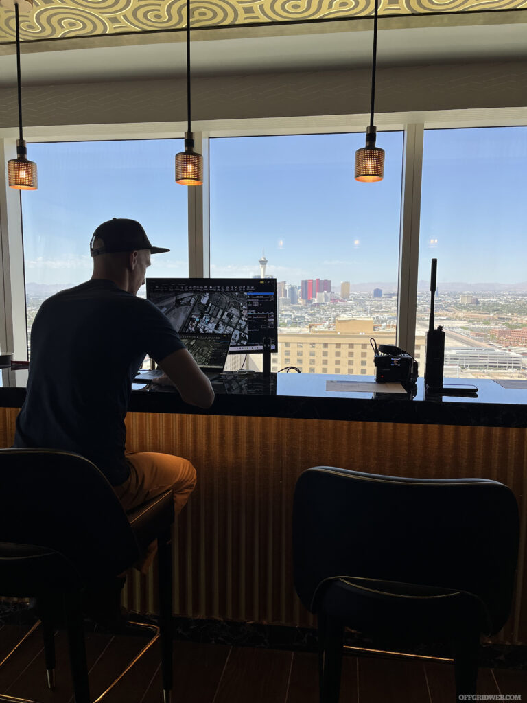 Photo of an adult male sitting at a bar looking at his computer.