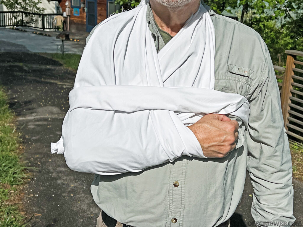 Using another bandage or swath of cloth to secure an arm sling to the torso.