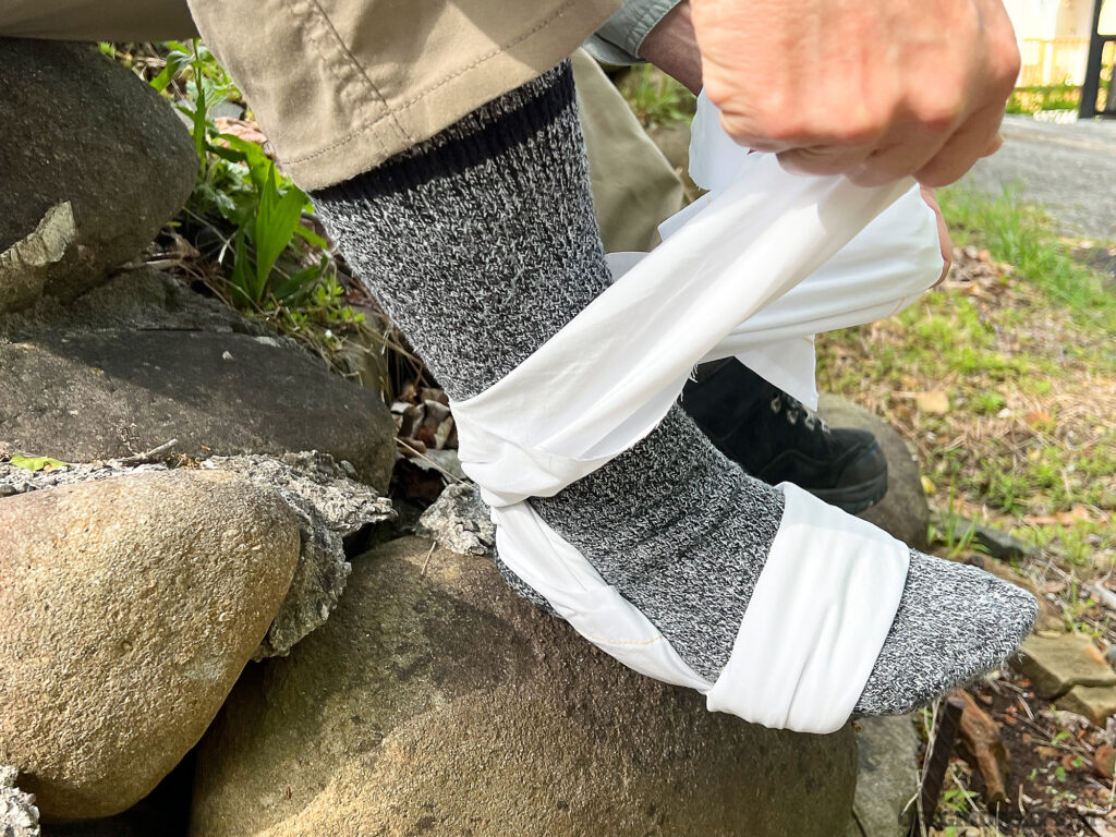 Tying an ankle support with a triangular bandage.