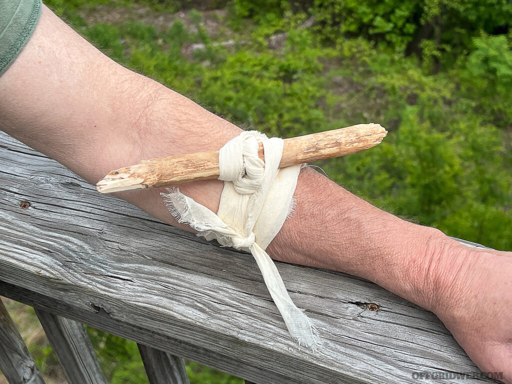 Securing a windlass stick with a triangular bandage.