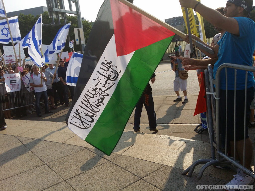 Pro Israel protesters stand across from pro Palestine protesters.