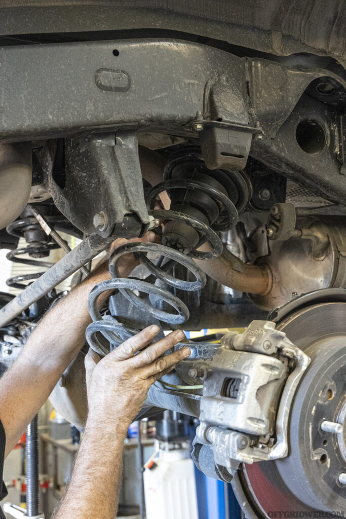 A piece of suspension being installed on an overland 4runner.