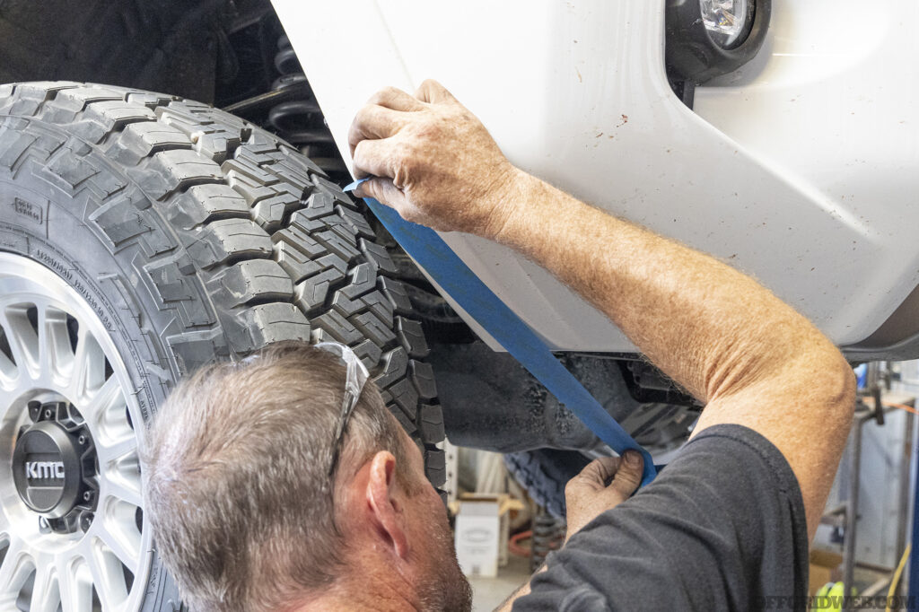 Mechanic taping off the trim of an overland 4runner.