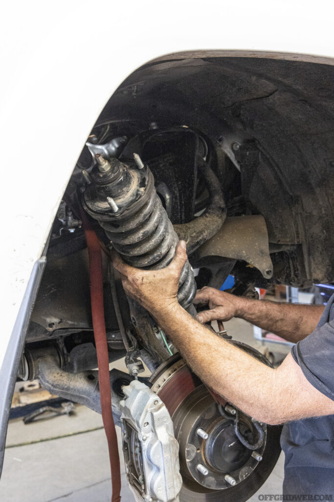 A piece of suspension being installed on an overland 4runner.