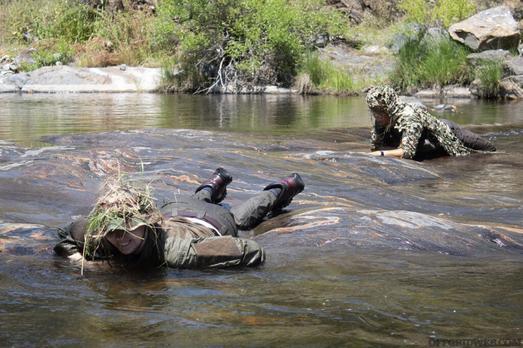 Camostalk 360 students crawling through a mountain river.