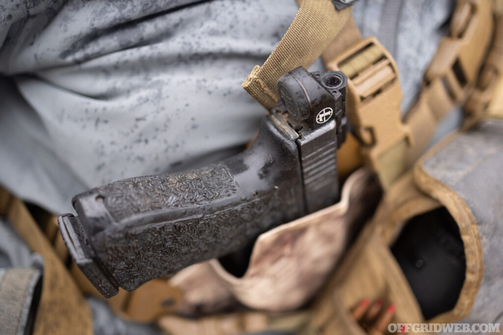 Photo of 10mm handgun in a chest holster.