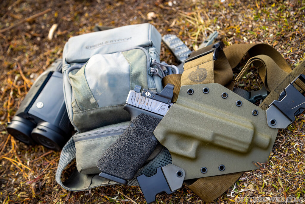 Photo of a holstered handgun lying on some hunting gear.