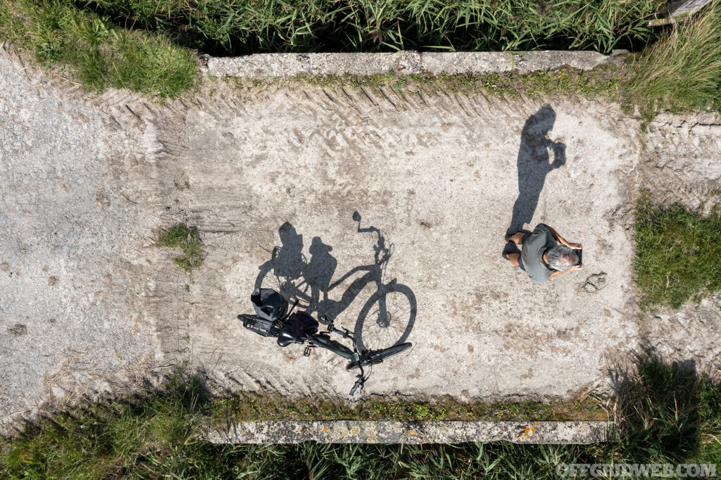 Shadow of drone pilot and his bicycle seen from straight above.