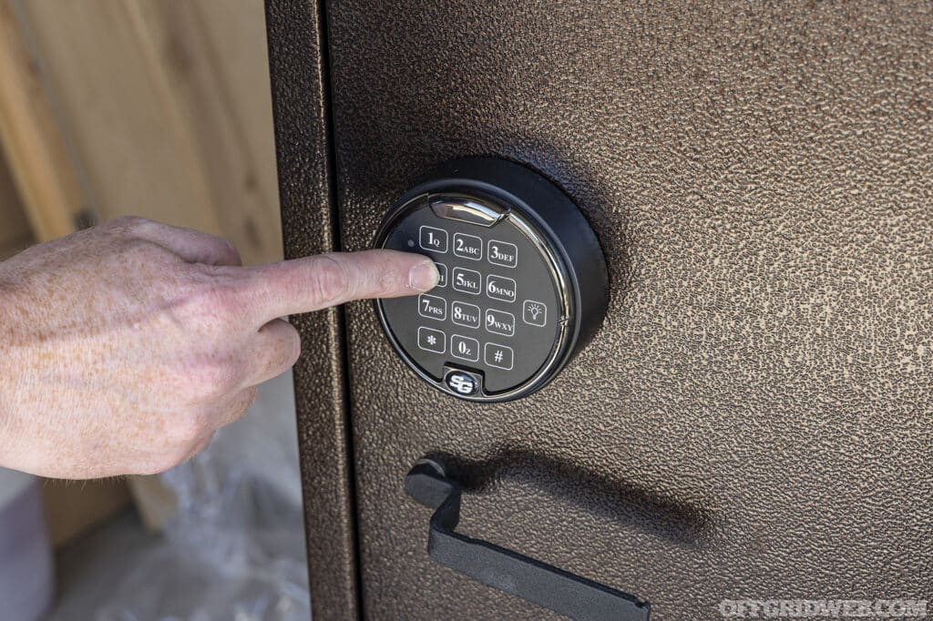 Someone programing the passcode on the door of the gun cabinet.