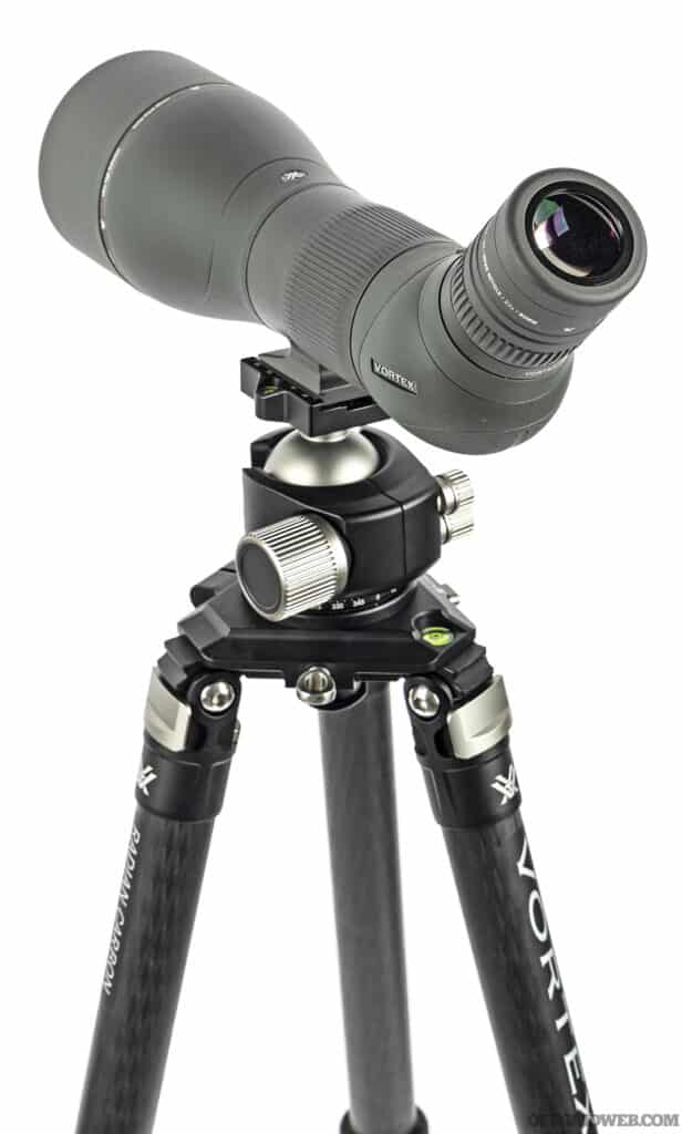 A spotting scope mounted to a tripod in the pros and cons of optics article.