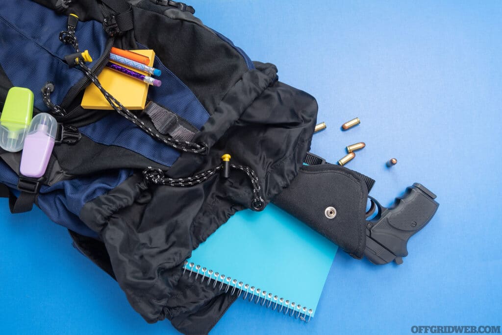 The contents of a backpack dumped out. There is a firearm in it.