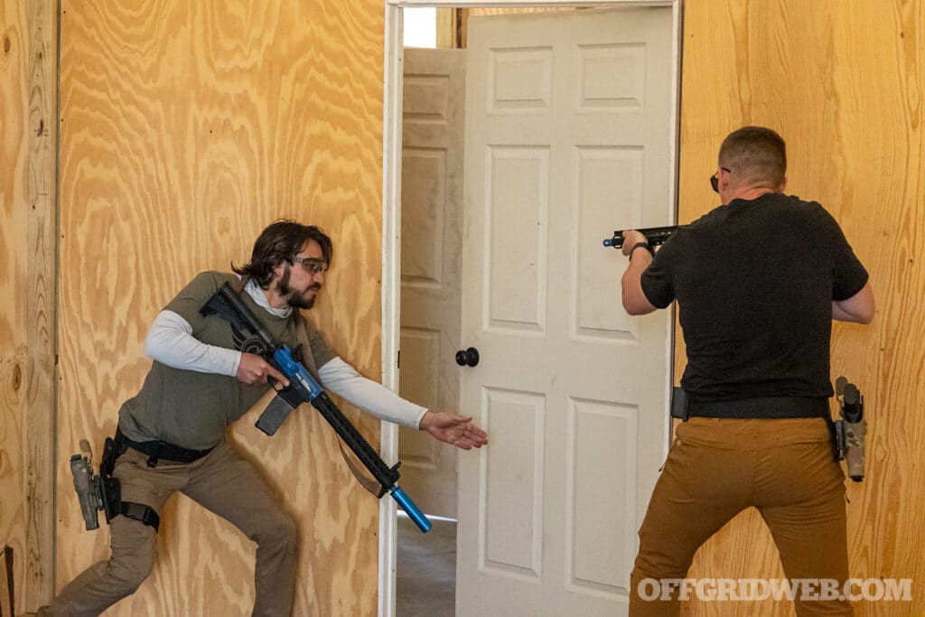 Image of two men doing a Full Spectrum Warrior Training Drill using Paintball guns and holstered hand guns in safariland holsters 