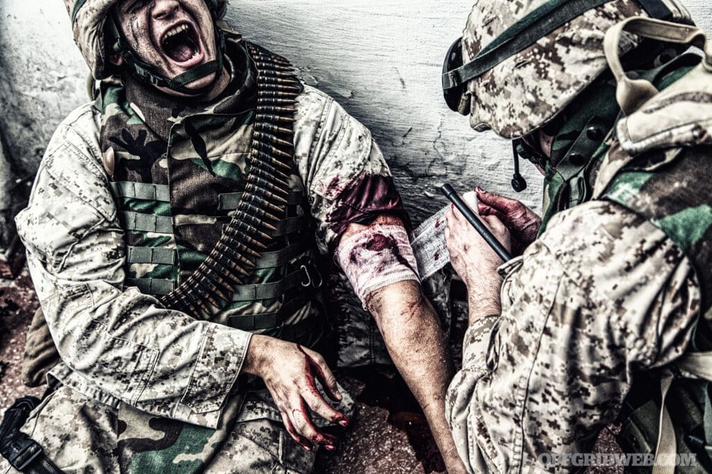 image of a soldier being treated for a Traumatic injury on his arm