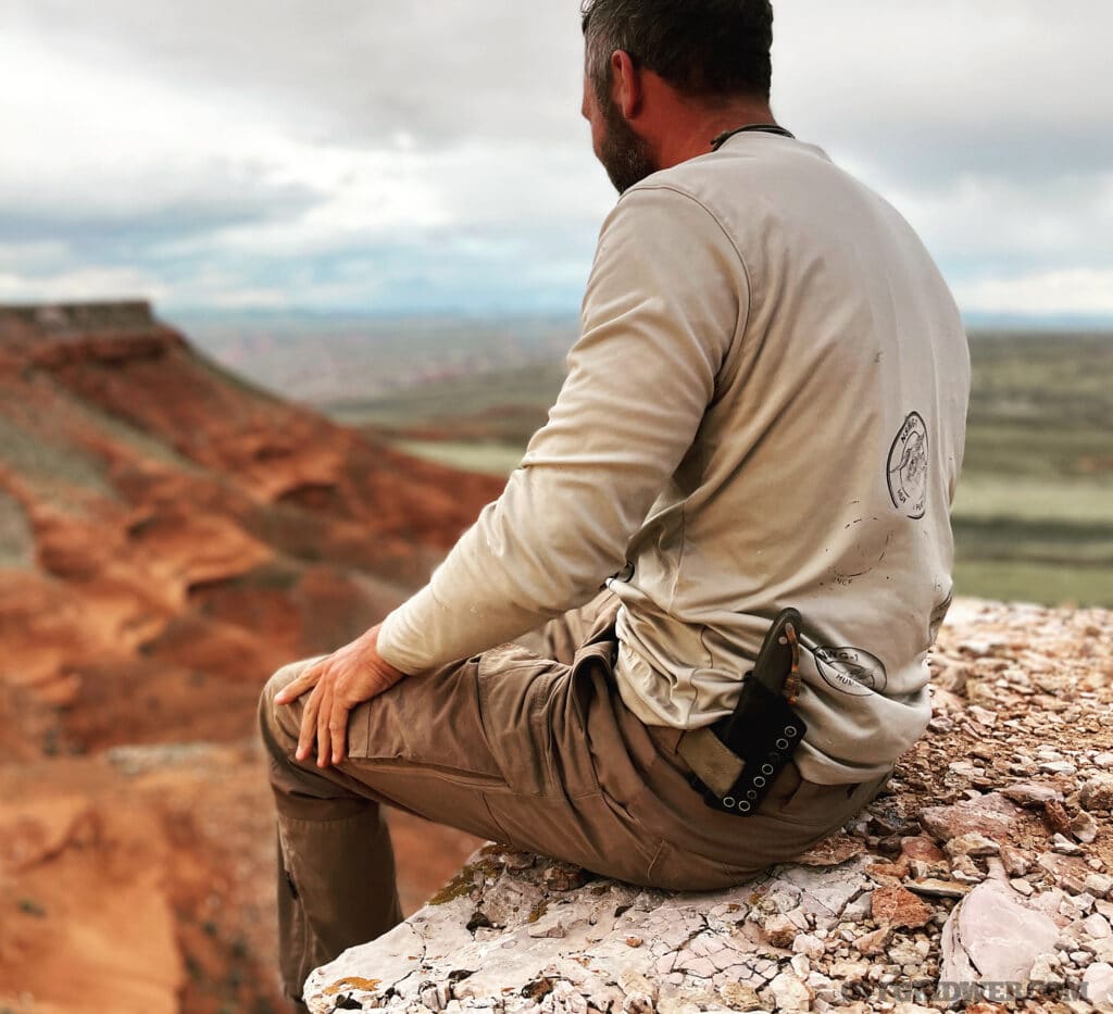 a mani sitting on a cliff side